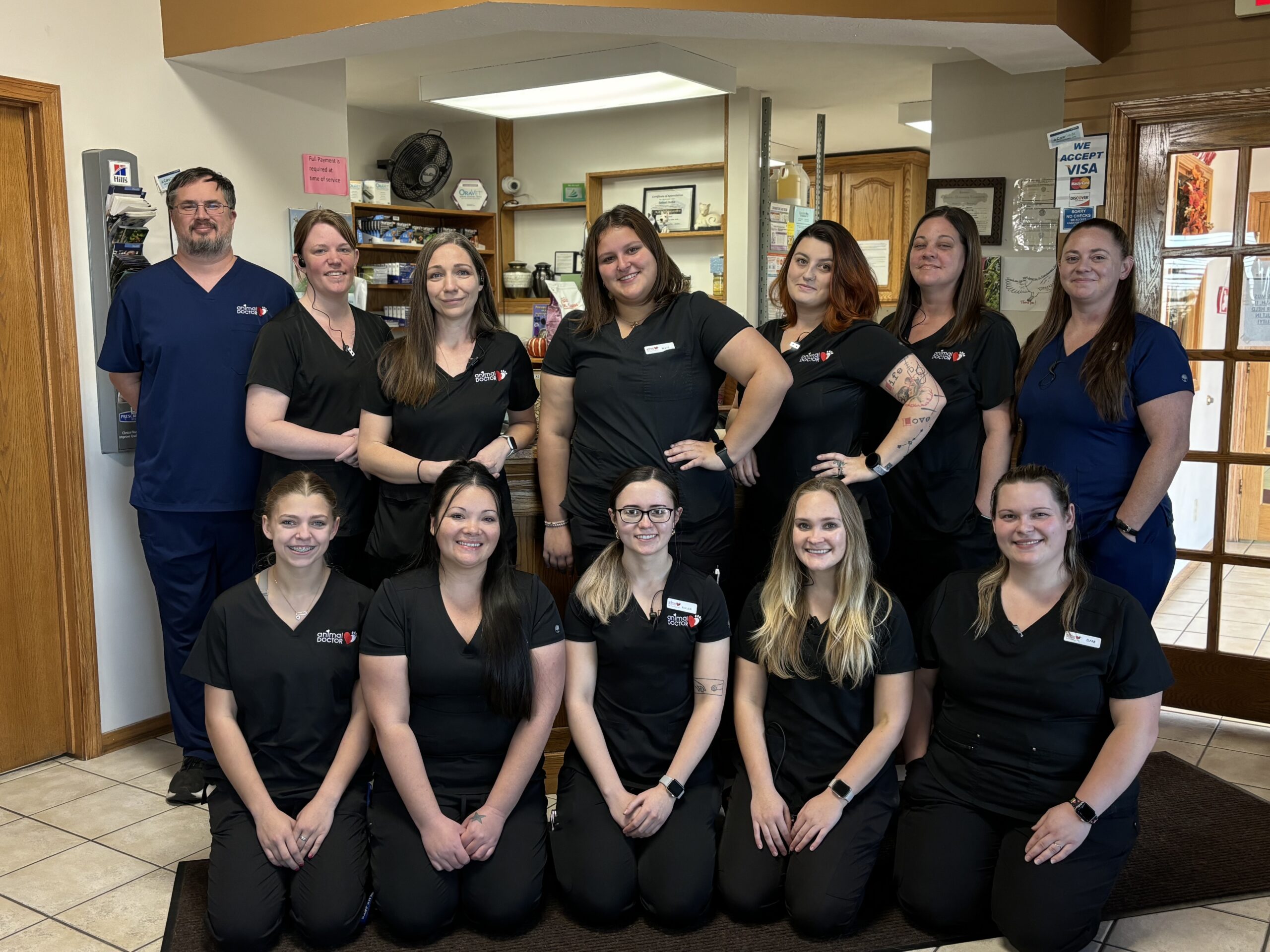 staff at animal doctor in junction city, KS posing in front of the building sign