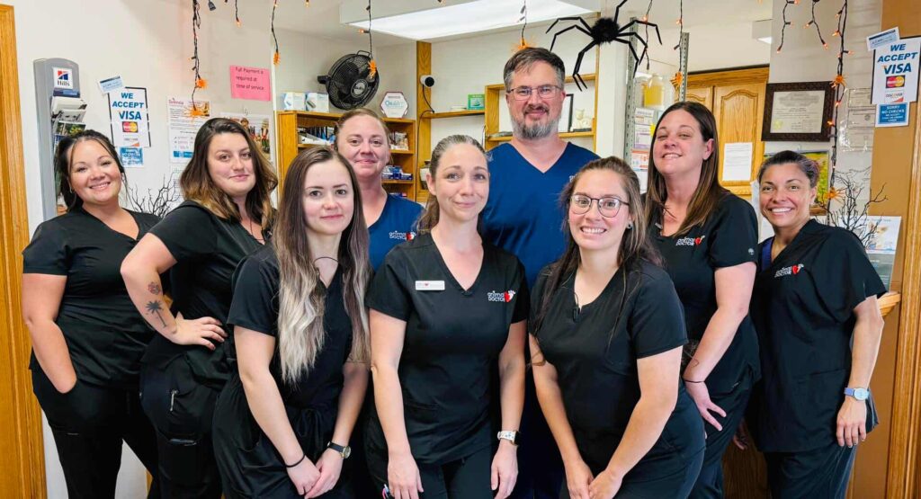 staff at animal doctor in junction city, KS posing in front of the building sign