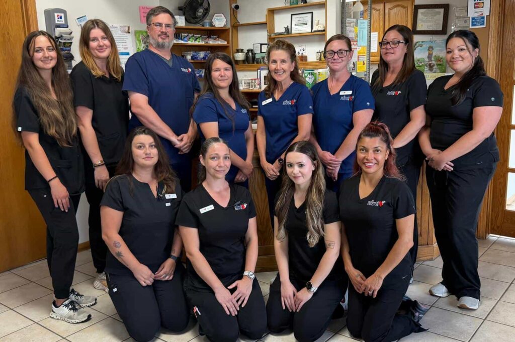 staff at animal doctor in junction city, KS posing in front of the building sign
